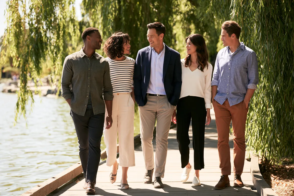 Willow Lake Loan team members walking and talking along a lakeside boardwalk lined with willow trees