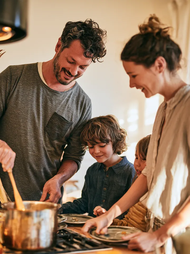 Family cooking dinner together after consolidating card balances into one fixed payment