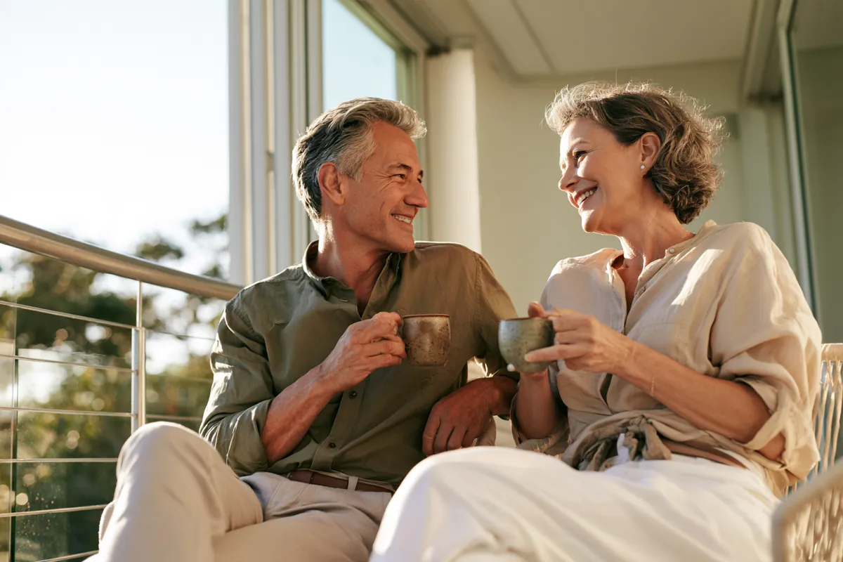 Couple sharing a pot of tea on a modern apartment balcony while reading the Willow Lake Loan terms of use